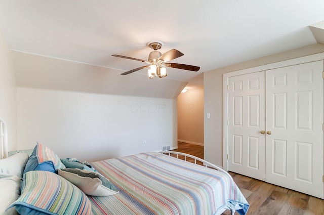 bedroom featuring ceiling fan, a closet, light hardwood / wood-style floors, and lofted ceiling