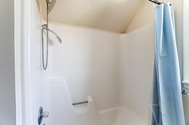 bathroom with walk in shower and vaulted ceiling