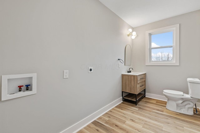 bathroom with wood-type flooring, vanity, and toilet