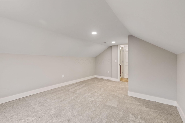 bonus room featuring light colored carpet and vaulted ceiling