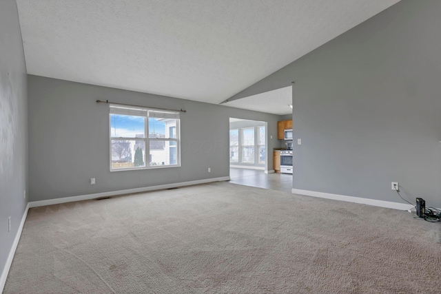 unfurnished living room featuring a textured ceiling, light carpet, and vaulted ceiling