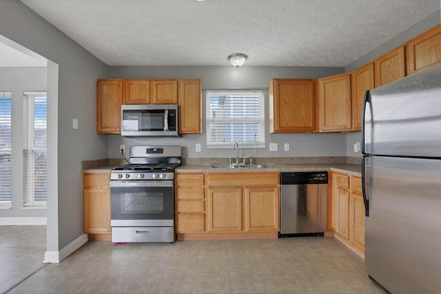 kitchen featuring a wealth of natural light, light brown cabinets, sink, and appliances with stainless steel finishes