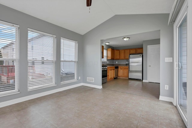 kitchen featuring ceiling fan, light tile patterned floors, stainless steel appliances, and vaulted ceiling