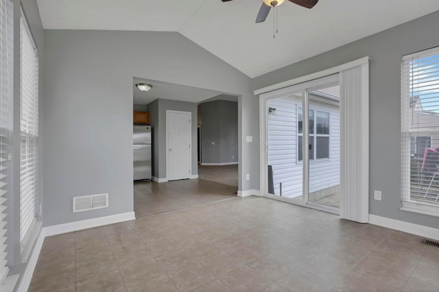 tiled empty room featuring vaulted ceiling and ceiling fan