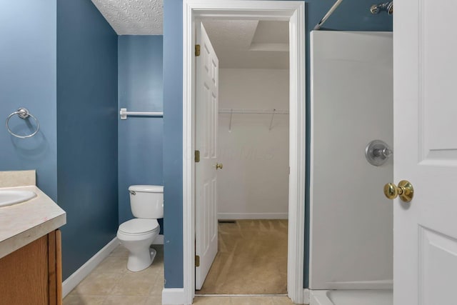 bathroom with tile patterned floors, a shower, a textured ceiling, toilet, and vanity