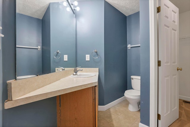 bathroom featuring vanity, toilet, and a textured ceiling