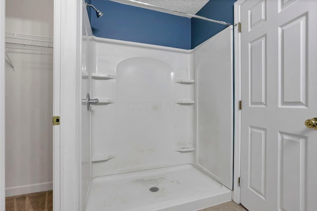 bathroom with a textured ceiling and walk in shower