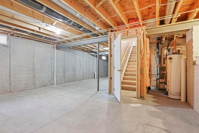 basement featuring brick wall and water heater