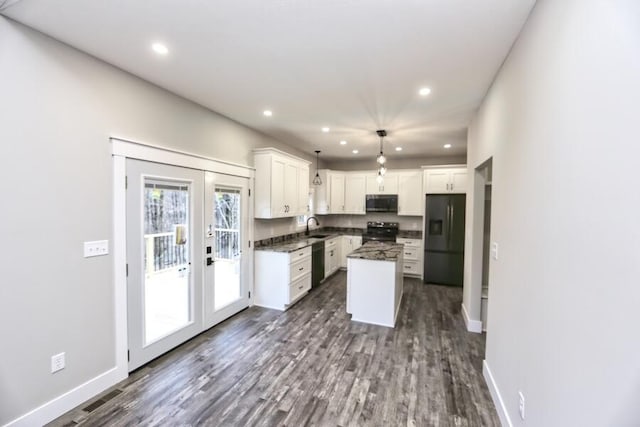 kitchen featuring black refrigerator with ice dispenser, a kitchen island, electric range, white cabinets, and hanging light fixtures