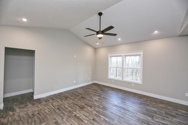 empty room with ceiling fan, vaulted ceiling, and dark hardwood / wood-style flooring