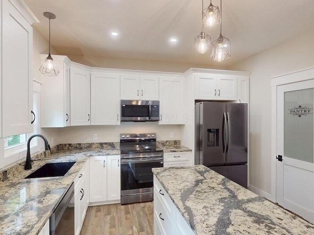 783 Crestrose Dr, Howard, OH 43028 - kitchen with stainless steel appliances, a sink, white cabinetry, light wood-type flooring, and decorative light fixtures