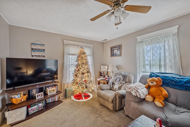 carpeted living room with plenty of natural light, ceiling fan, and a textured ceiling