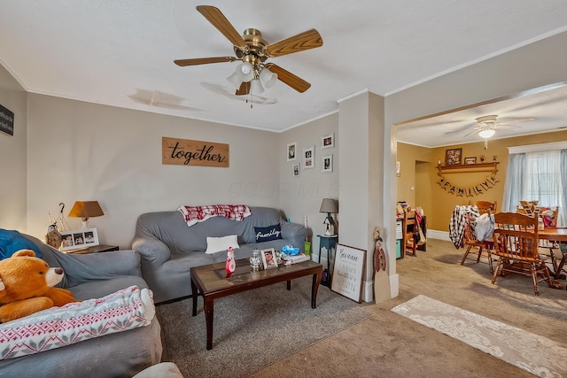 living room featuring carpet, ceiling fan, and crown molding