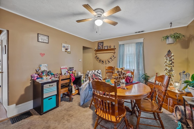 carpeted dining space with ceiling fan, a textured ceiling, and ornamental molding