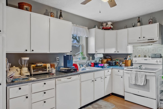 kitchen with white appliances, ceiling fan, sink, white cabinets, and light hardwood / wood-style floors