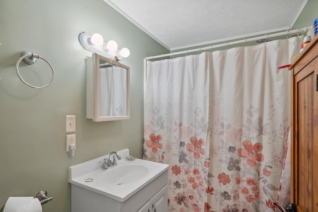 bathroom featuring a shower with curtain, vanity, ornamental molding, and a textured ceiling