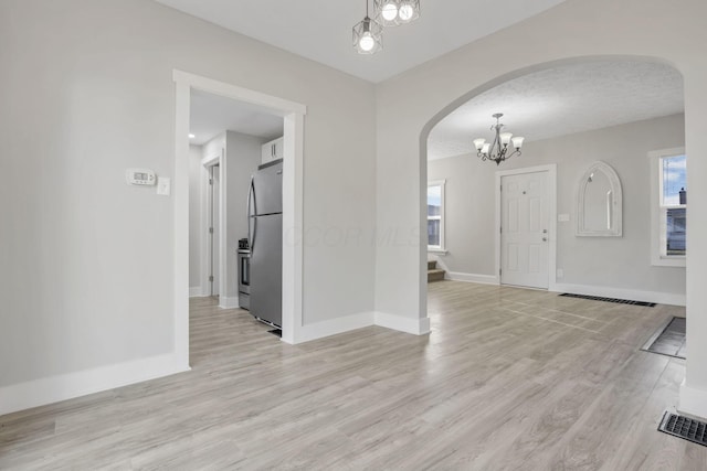 interior space featuring light hardwood / wood-style flooring and a notable chandelier