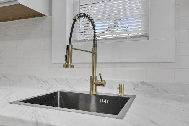 room details with light stone countertops and sink