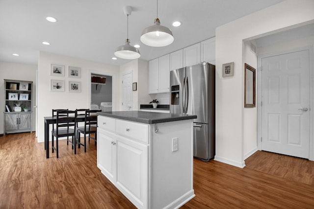 kitchen featuring white cabinetry, stainless steel fridge with ice dispenser, a kitchen island, and dark wood-type flooring