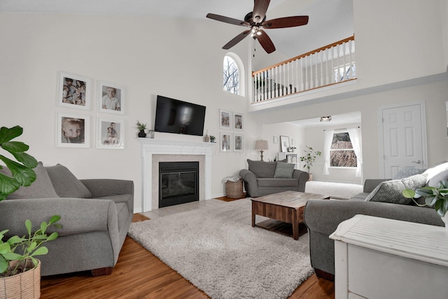 living room featuring a high ceiling, ceiling fan, and hardwood / wood-style floors