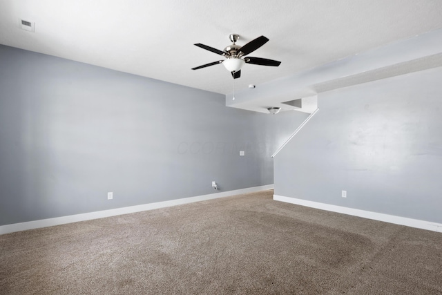 unfurnished room featuring a ceiling fan, visible vents, baseboards, and carpet flooring