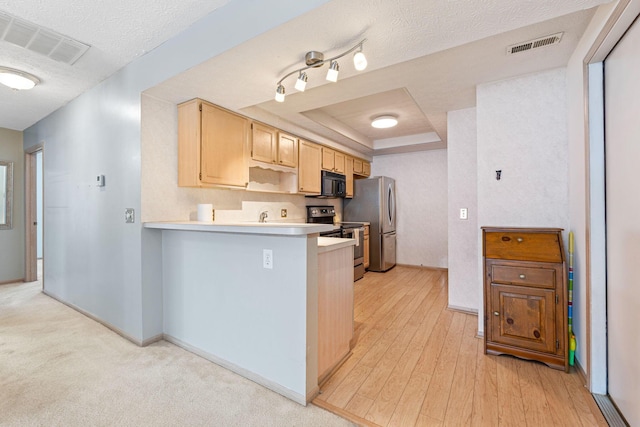 kitchen featuring visible vents, appliances with stainless steel finishes, a raised ceiling, and a textured ceiling