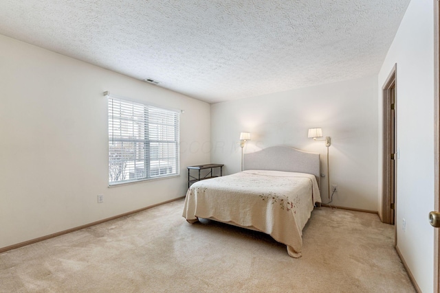 bedroom featuring baseboards, visible vents, and light colored carpet