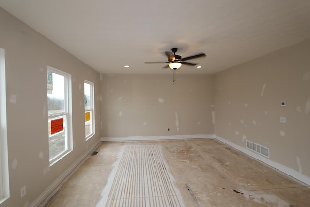 spare room with ceiling fan and plenty of natural light