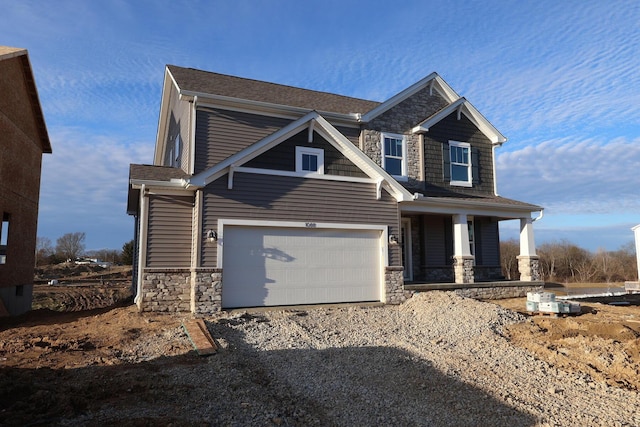 craftsman house featuring driveway, stone siding, and a garage