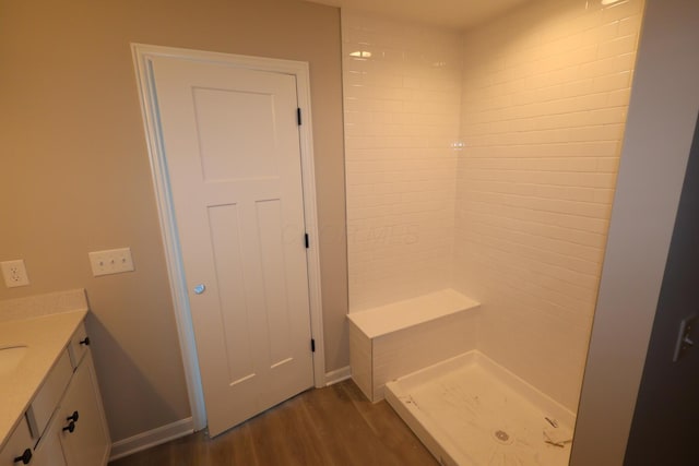 full bathroom with a stall shower, baseboards, wood finished floors, and vanity