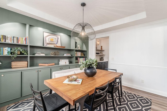 dining area featuring a tray ceiling and hardwood / wood-style flooring