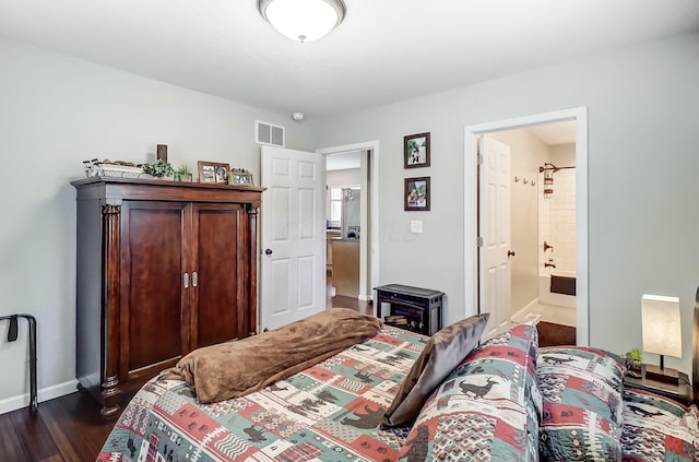 bedroom featuring dark hardwood / wood-style flooring and connected bathroom