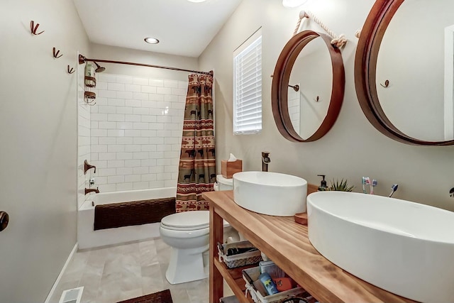 full bathroom featuring tile patterned flooring, toilet, shower / bathtub combination with curtain, and sink