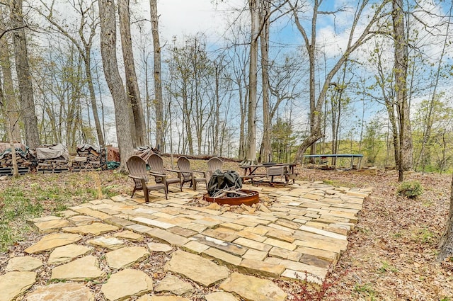 view of patio / terrace with a trampoline and an outdoor fire pit