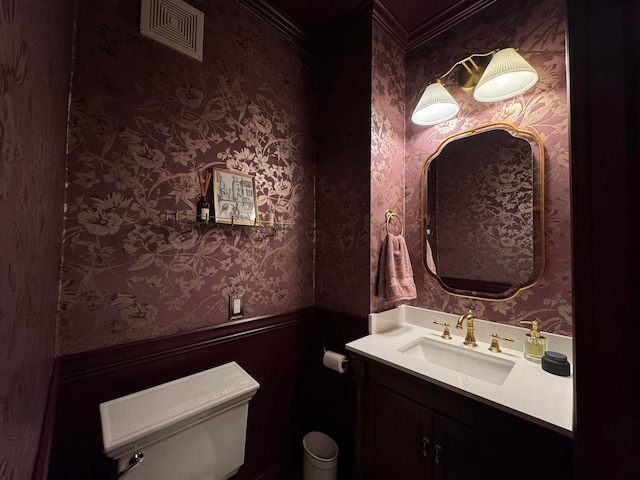 bathroom with vanity, toilet, and crown molding