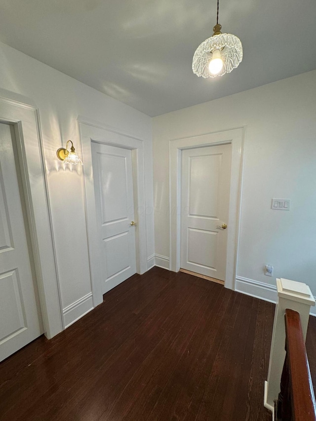 hallway with dark hardwood / wood-style flooring