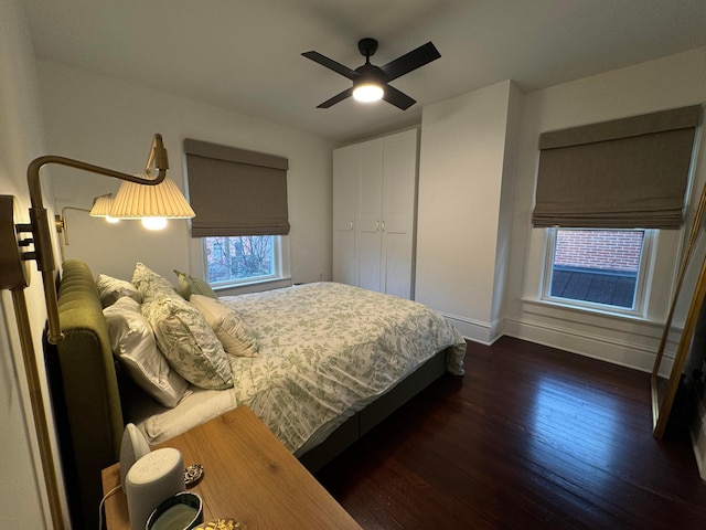 bedroom with a closet, ceiling fan, and dark wood-type flooring