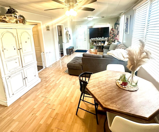 dining space with light hardwood / wood-style flooring and ceiling fan