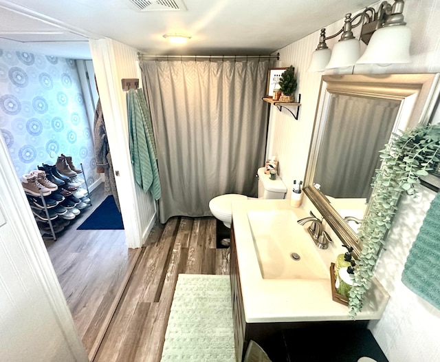 bathroom with vanity, toilet, and wood-type flooring