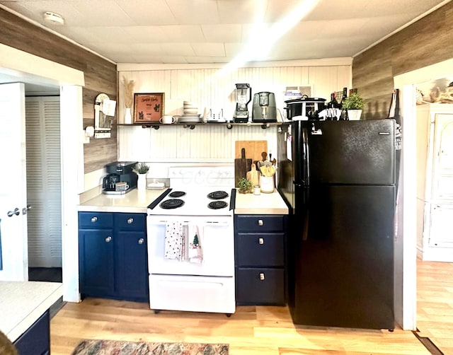 kitchen with blue cabinetry, white range with electric cooktop, wood walls, black refrigerator, and light wood-type flooring