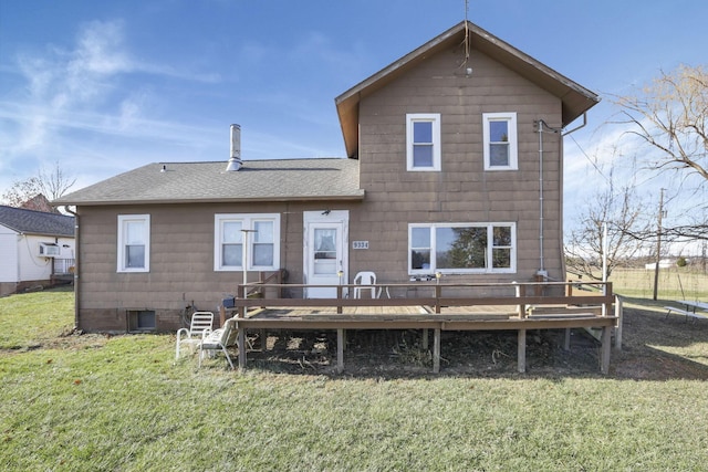 rear view of house featuring a lawn and a deck