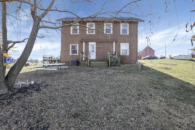 view of front of home with central AC and a front lawn