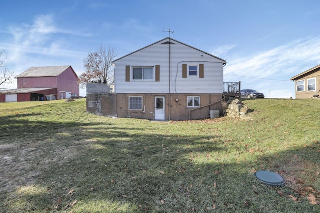 back of property featuring central AC unit and a yard