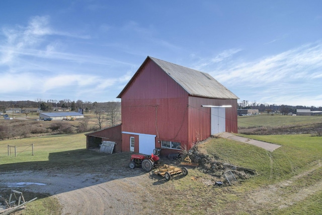 view of outdoor structure featuring a rural view and a yard