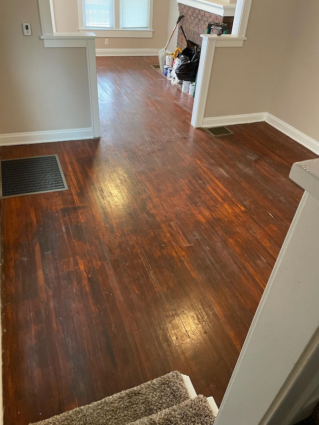 interior details featuring hardwood / wood-style flooring and a brick fireplace