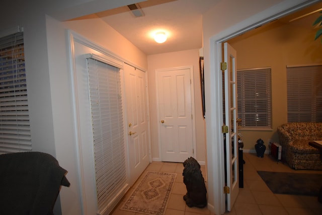 hall featuring light tile patterned floors