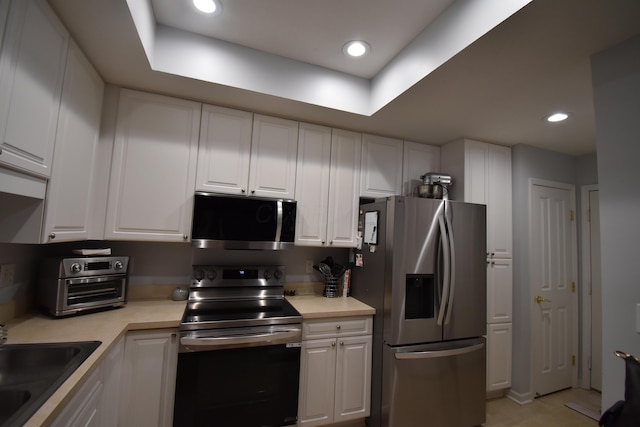 kitchen with stainless steel appliances, sink, and white cabinets