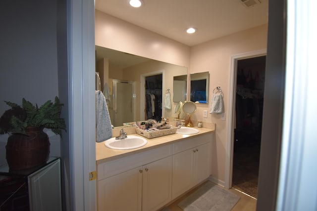 bathroom with vanity and a shower with door