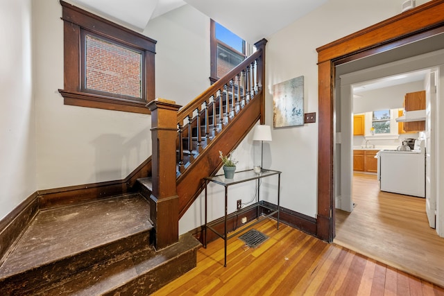 stairs featuring sink and hardwood / wood-style floors