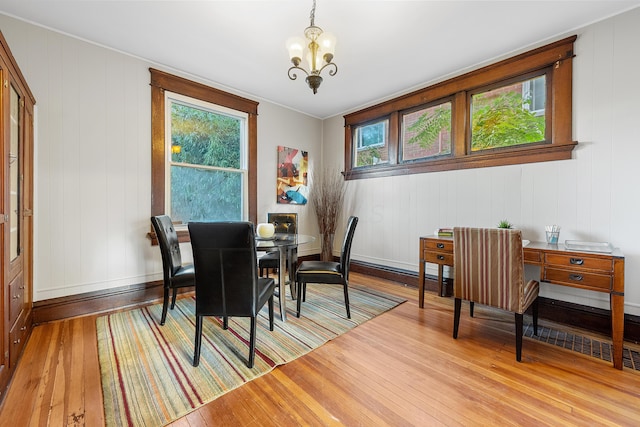 dining area with a notable chandelier and light hardwood / wood-style flooring